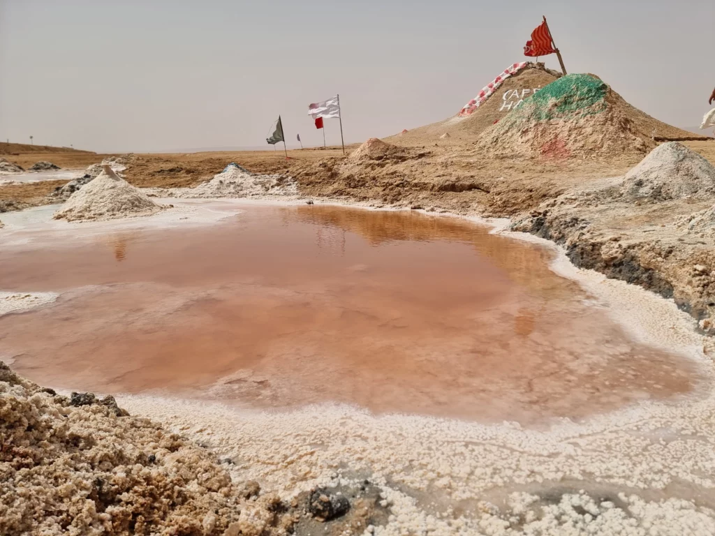 Pink saltwater pool and desert terrain at Chott el Jerid in Tunisia, an ideal filming location for foreign crews.